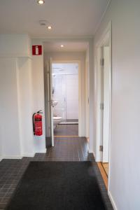 a hallway with a bathroom with a toilet and a tub at Landvetter Hotell in Härryda