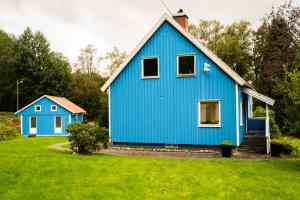 two blue houses in a yard with green grass at Landvetter Hotell in Härryda
