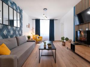 a living room with a couch and a tv at ClairChêne - Cosy Centre Parking Spacieux Familial in Verdun-sur-Meuse
