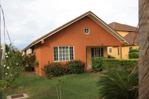 una casa naranja con patio en Hartland Palms, en Priory