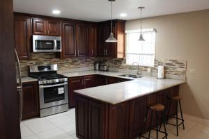 a kitchen with wooden cabinets and a counter top at Soleil Hartland Palms in Priory
