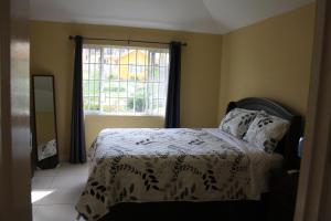 1 dormitorio con cama y ventana en Hartland Palms, en Priory