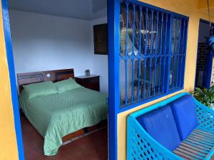 um quarto com uma cama e um portão de ferro azul em DinoAgro Potrero Grande em Moniquirá