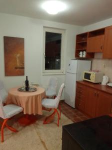Lukavica的住宿－Stan na dan，厨房配有桌椅和白色冰箱。