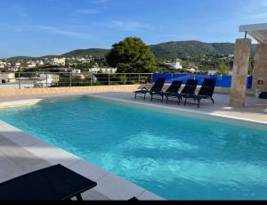 una piscina con due sedie a sdraio accanto di Souvala /Aegina. Excellent location Luxury villa. a Vathí