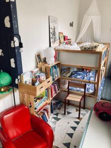 a room with a red chair and a bunk bed at Paris : Appartement familial avec parking privé in Clichy