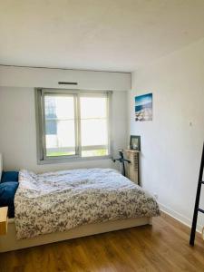 a bedroom with a bed and a window at Paris : Appartement familial avec parking privé in Clichy