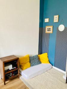 a living room with a couch with yellow pillows at Paris : Appartement familial avec parking privé in Clichy