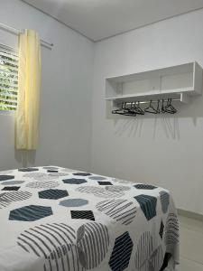 Habitación blanca con cama y escritorio. en Lotus Antunes Beach, en Antunes