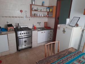 a small kitchen with a stove and a refrigerator at LO DE LOPEZ in Azul