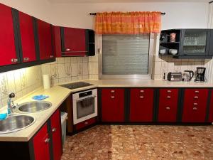 a kitchen with red cabinets and a sink at Ferienhaus International 2 in Bad Harzburg