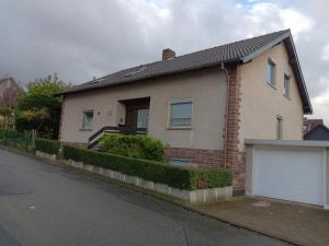 a brick house with a white garage on a street at Ferienhaus International 2 in Bad Harzburg