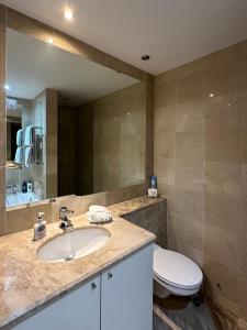 a bathroom with a sink and a toilet and a mirror at Canary Wharf 1 bed apartment in London