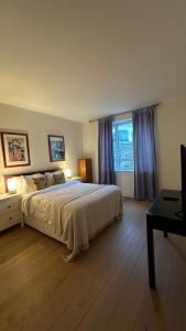 a bedroom with a large bed and a large window at Canary Wharf 1 bed apartment in London