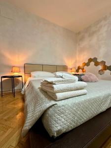 a bedroom with a large bed with white sheets and pillows at CASAVACANZETOFFEE in Bologna
