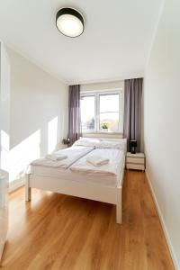 a white bed in a room with a window at Marel - apartament 31 sauna Polanica Zdrój in Polanica-Zdrój