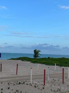 una red de voleibol en una playa cerca del océano en Lotus Antunes Beach en Antunes