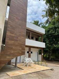 un edificio con dos sillas blancas delante de él en Lotus Antunes Beach en Antunes