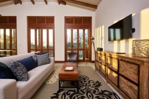 een woonkamer met een bank en een tv bij Las Catalinas - Beachfront GUESTHOUSE for 6 persons - Alouatta Guesthouse in Playa Danta