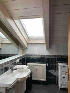 a bathroom with two sinks and a skylight at Zweite Heimat in Mühldorf in Mühldorf