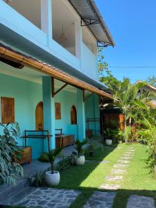 una casa con un jardín delante de ella en Secret Spot Surf and Stay, en Kuta Lombok