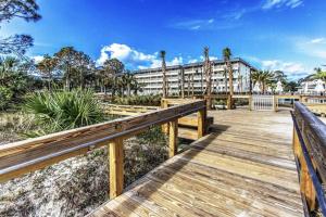 a wooden deck with a building in the background at Ocean Dunes Villas in Hilton Head Island
