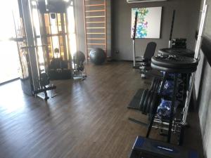 ein Fitnessstudio mit mehreren Laufbändern und Hanteln in einem Raum in der Unterkunft Flat Por Temporada no Edifício Time Maceió-AL in Maceió