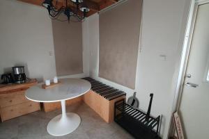 um pequeno quarto com uma mesa e um banco em Nyhem stugan em Våxtorp