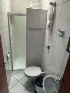 a small bathroom with a toilet and a sink at Quarto Laurinda 3 in Guararema