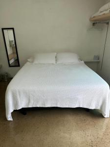 a bed in a room with a white bedspread at Tropical Oasis On The Water Crown Point in San Diego