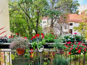 een tuin met bloemen in potten op een hek bij Green balcony & king size bed in Praag