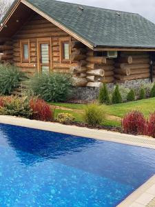 Cabaña de madera con piscina frente a una casa en VIP ШАЛЕ ТИША, 