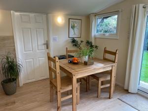 a dining room table and chairs with oranges on it at Ferncroft Garden Studio in Histon
