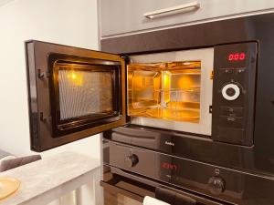 a microwave oven with its door open in a kitchen at Apartamenty KTW Park Śląski Bytkowska 103A in Katowice