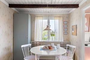 comedor con mesa blanca y sillas en Idylliskt hus med havsutsikt, en Sölvesborg