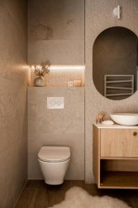 a bathroom with a toilet and a sink and a mirror at Chalet V11 by Villa 11 Folk & Design in Zakopane
