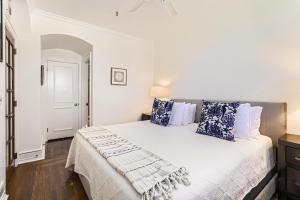 a white bedroom with a large bed with blue pillows at Palm Beach Hotel in Palm Beach