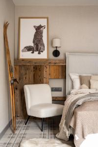 sypialnia z łóżkiem, krzesłem i zdjęciem w obiekcie Chalet V11 by Villa 11 Folk & Design w Zakopanem