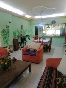 sala de estar con sofá naranja y mesa en Casa céntrica antigua completa en Orizaba