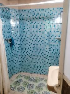 y baño con ducha de azulejos azules. en Casa céntrica antigua completa en Orizaba