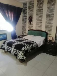 a bedroom with a black and white bed with a window at Casa céntrica antigua completa in Orizaba