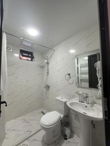 a white bathroom with a toilet and a sink at Bina N28 in Kutaisi