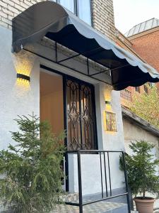 a front door of a house with a blue awning at Bina N28 in Kutaisi