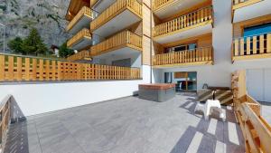 eine große Terrasse mit Holzbalkonen auf einem Gebäude in der Unterkunft Spacieux appart 3,5 pièces incl Jaccuzzi Privé in Leukerbad