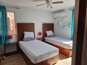 a bedroom with two beds and a ceiling fan at Amplio Departamento in Cancún