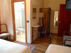 a bedroom with a bathroom with a toilet and a sink at Locanda Villa Moderna in Genoa