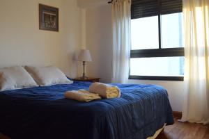 Un dormitorio con una cama azul con un osito de peluche. en Bello 9no piso en Plaza Italia (con cochera) en La Plata