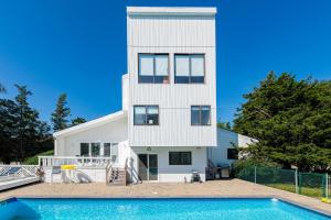 a white house with a swimming pool in front of it at Meadow Lane Estate in Westhampton Beach