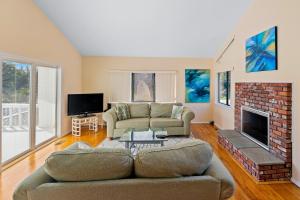 a living room with a couch and a fireplace at Meadow Lane Estate in Westhampton Beach
