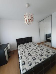 a bedroom with a bed and a chandelier at Vila Vati - Arena Pitesti in Piteşti